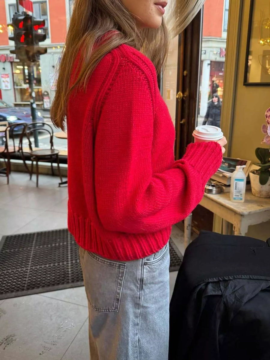 Red ribbed round-neck knit sweater with long sleeves and a comfortable fit.