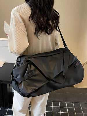 Black Oxford cloth travel bag with adjustable strap and buckle details.