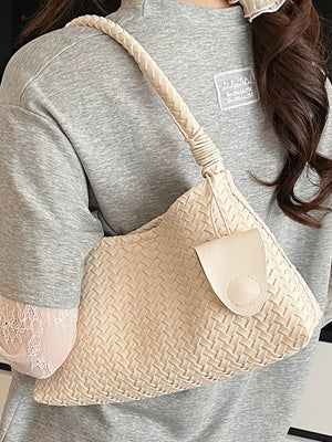 Off-white woven shoulder bag with braided strap and leather flap closure