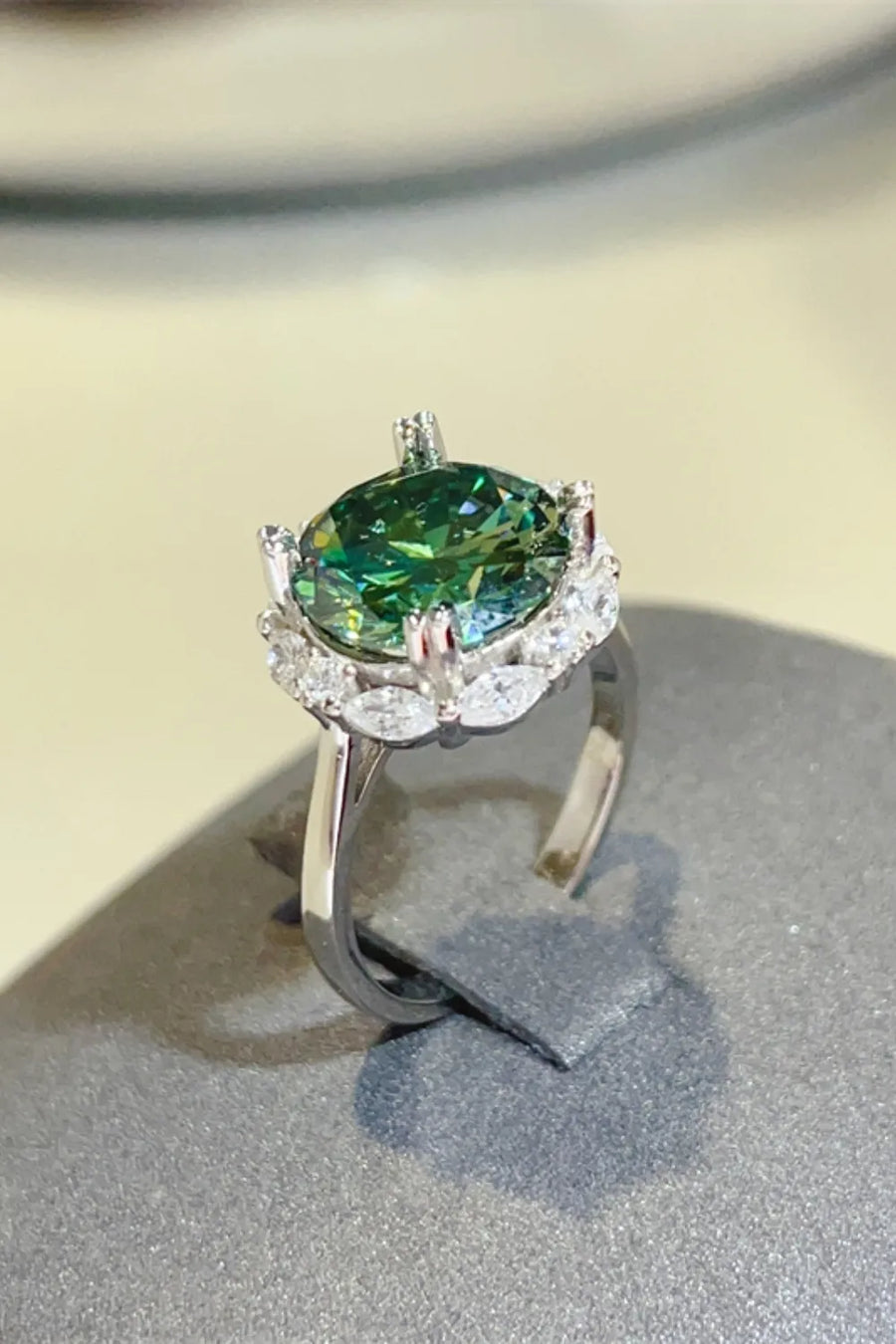 Emerald halo sterling silver cocktail ring with dark green center stone and diamond accents.