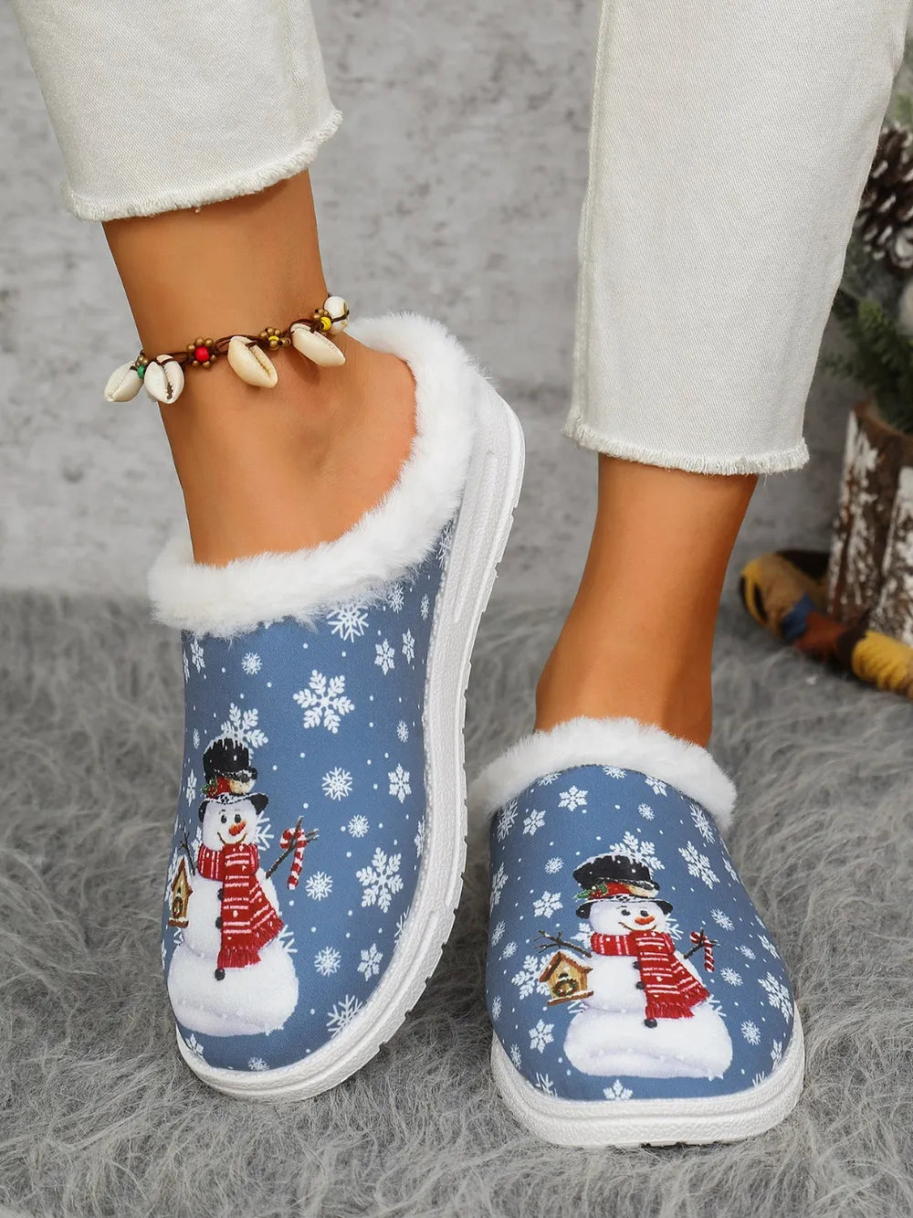 Blue snowman print sherpa lined holiday slides with white snowflakes.