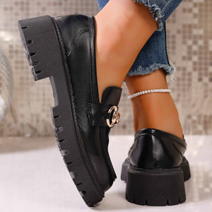 Chunky black lug sole loafers with gold chain detail and thick platform sole.
