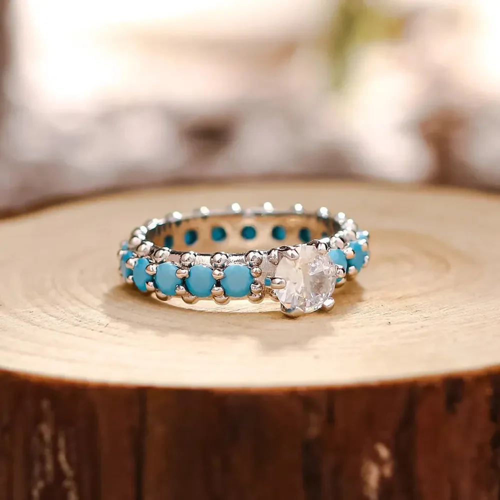 Turquoise bezel and solitaire ring in 925 sterling silver with a clear center stone.