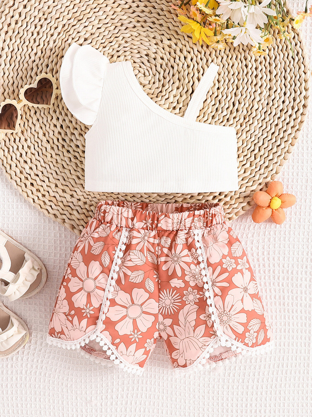 Baby asymmetrical top with ruffle sleeve and floral shorts set in coral pink.
