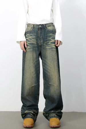 Distressed denim wide-leg trousers in medium wash with a relaxed fit and vintage fade.