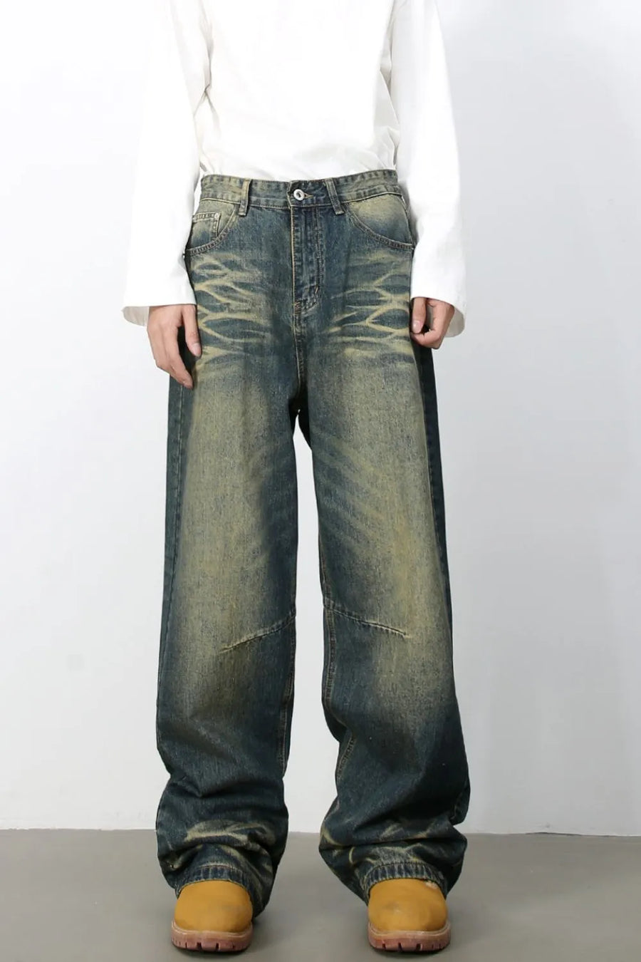 Distressed denim wide-leg trousers in medium wash with a relaxed fit and vintage fade.