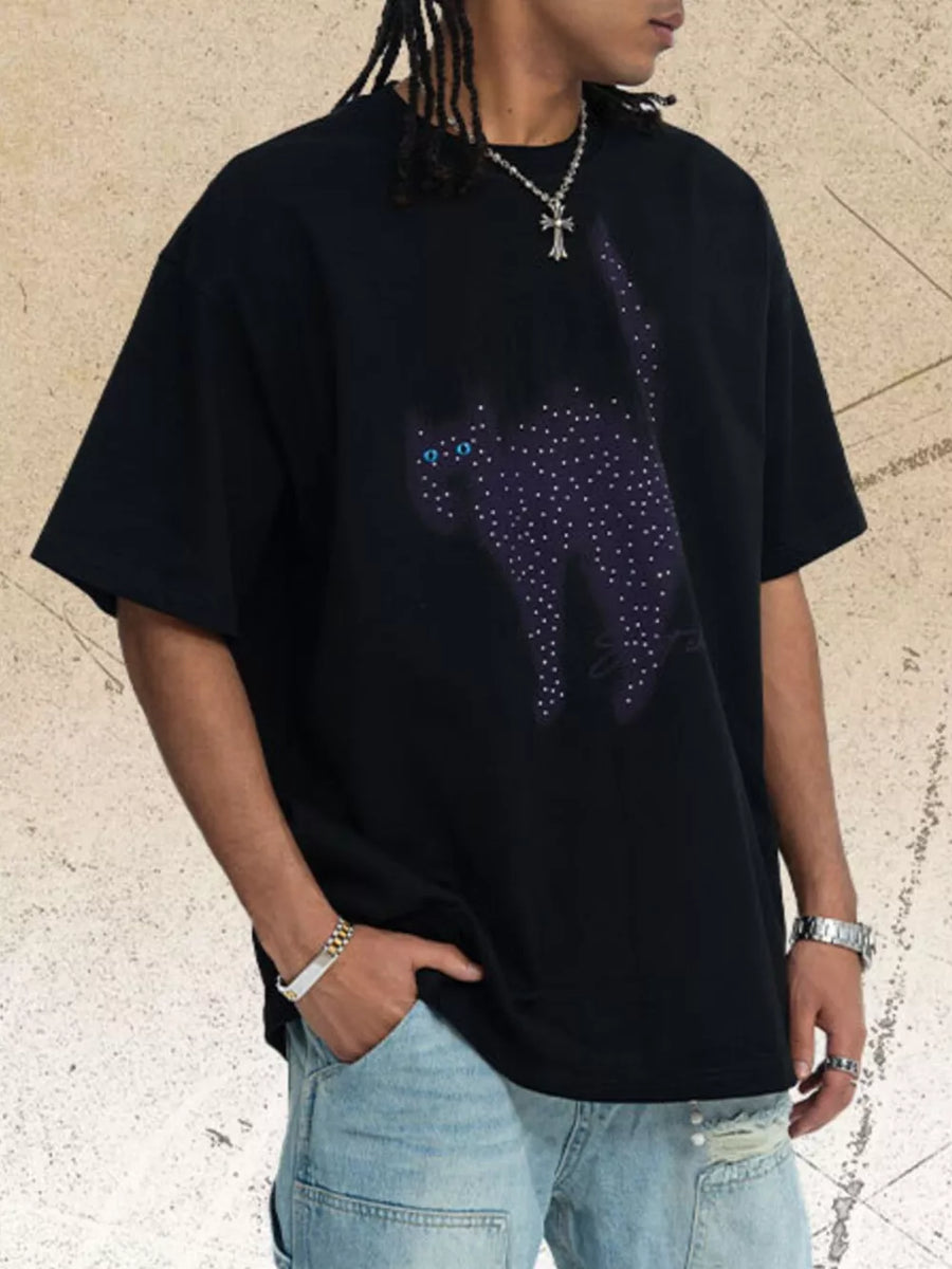 Black cotton t-shirt with a rhinestone cat graphic and blue eyes.