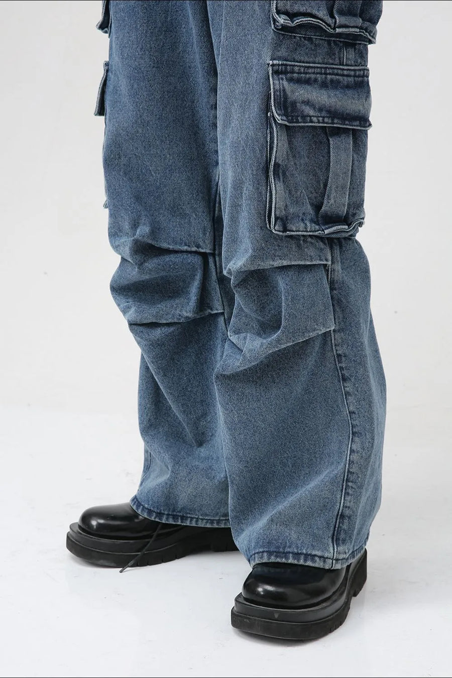 Baggy denim cargo pants in medium wash with multiple large pockets.