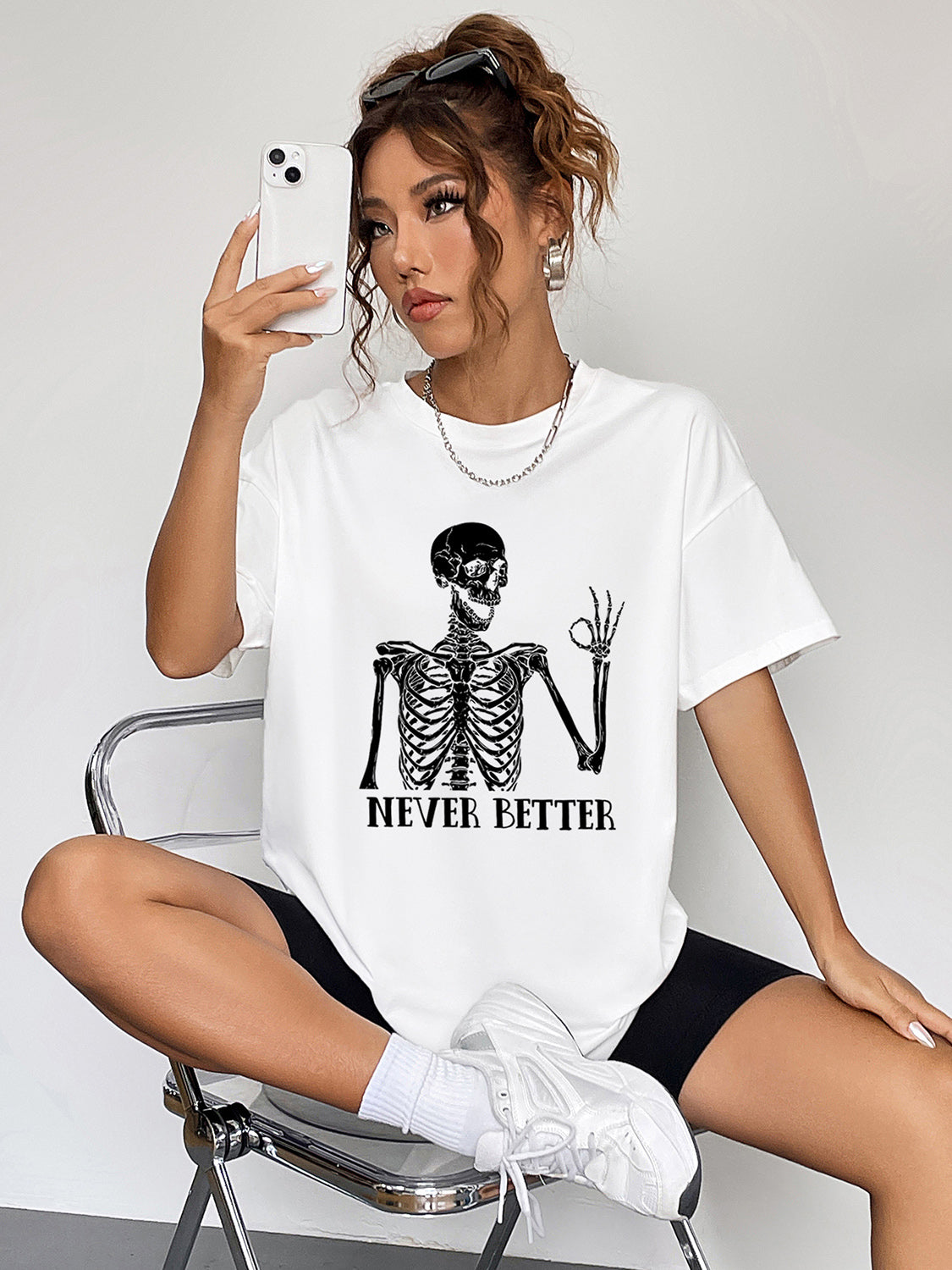 White oversized tee with skeleton graphic and "Never Better" text