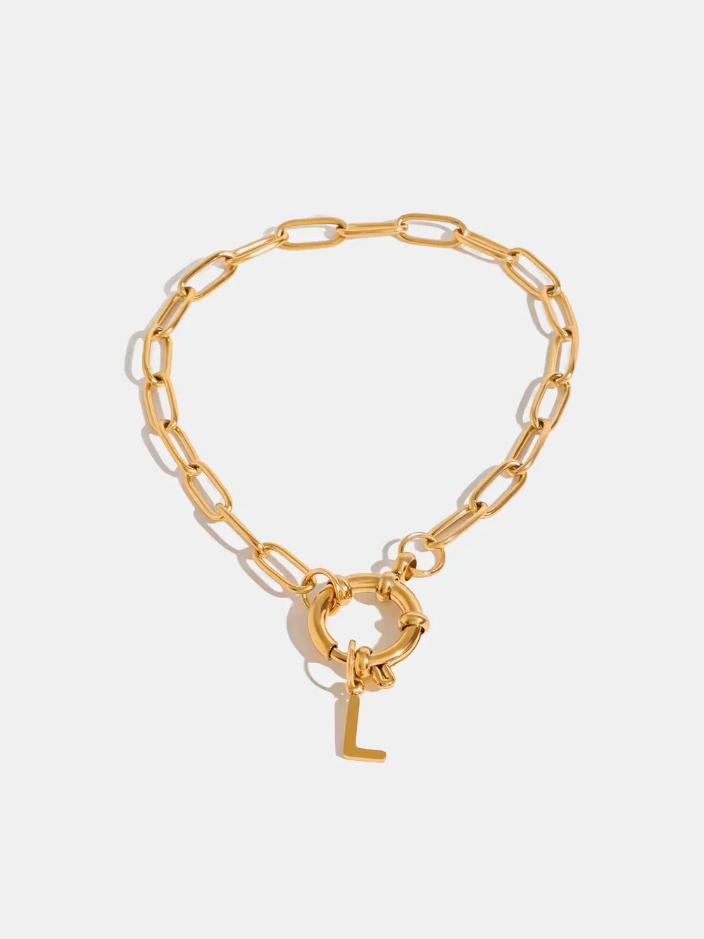 Gold chunky chain bracelet with a circular clasp and an initial L charm.