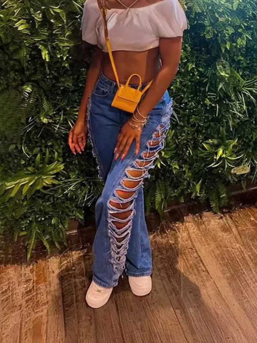 Blue denim jeans with distressed side cutouts and lace-up detail.