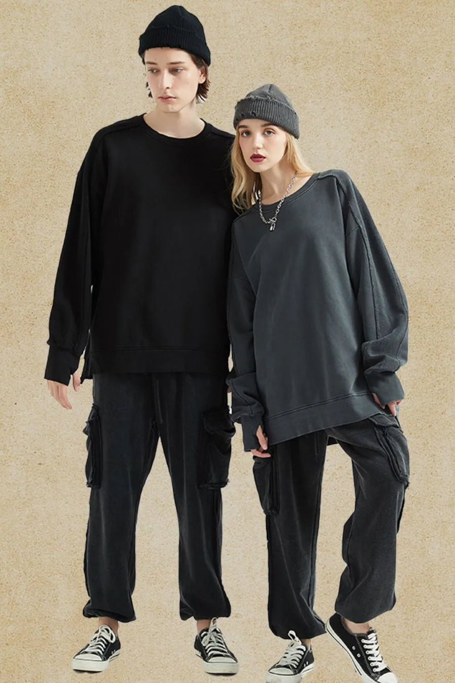 Oversized sweatshirt in dark gray with raw-edge seams and crew neck, styled casually.