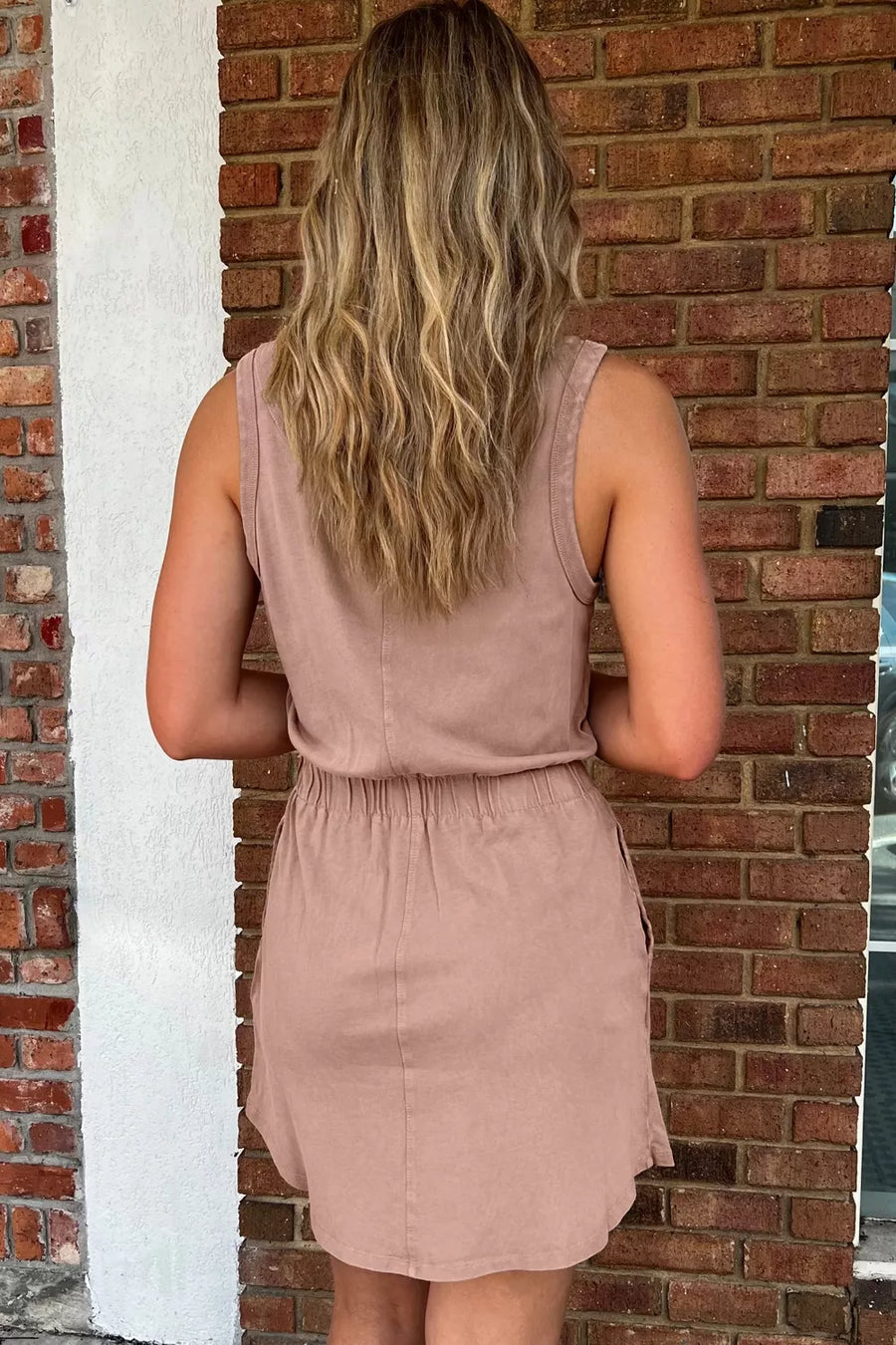 Sleeveless taupe cotton dress with elastic waist and pockets.