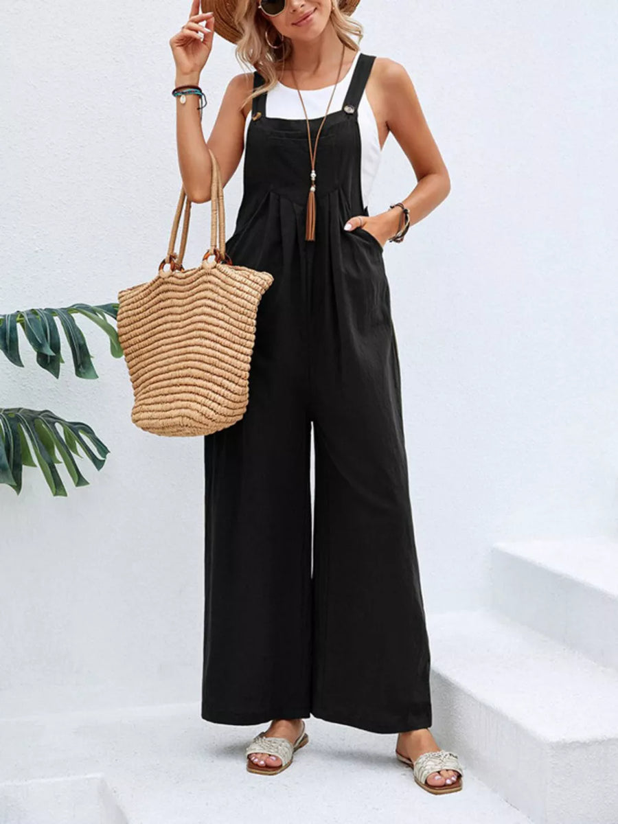 Black wide-leg romper with pockets, adjustable straps, and button details.