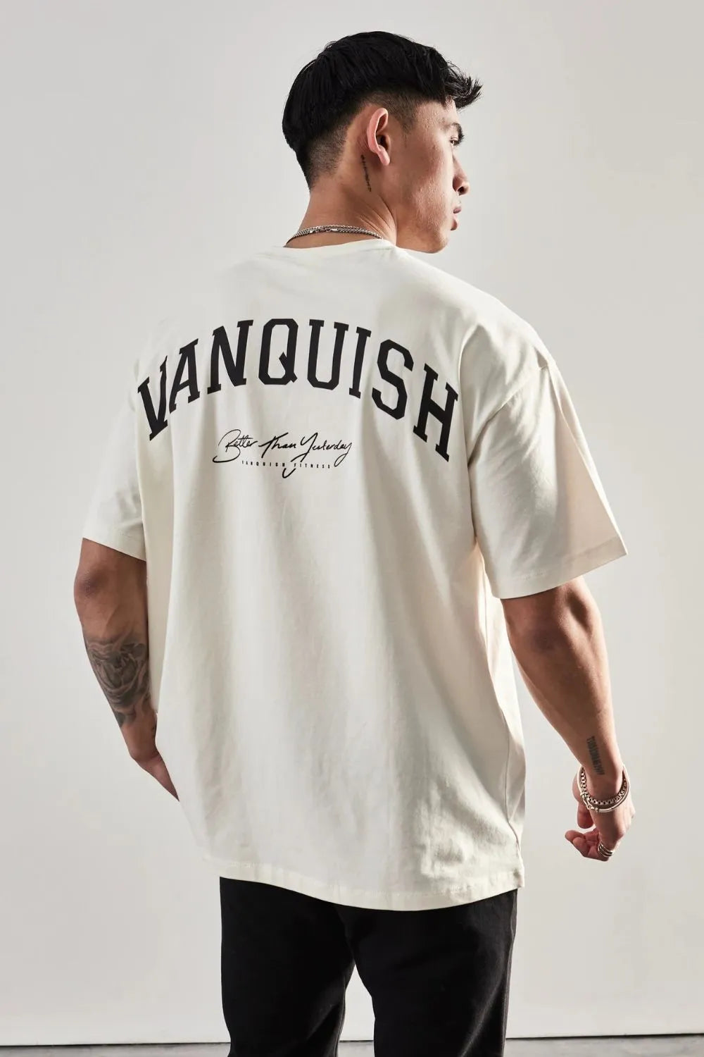 Oversized white graphic tee with "Vanquish" back print and script detail.