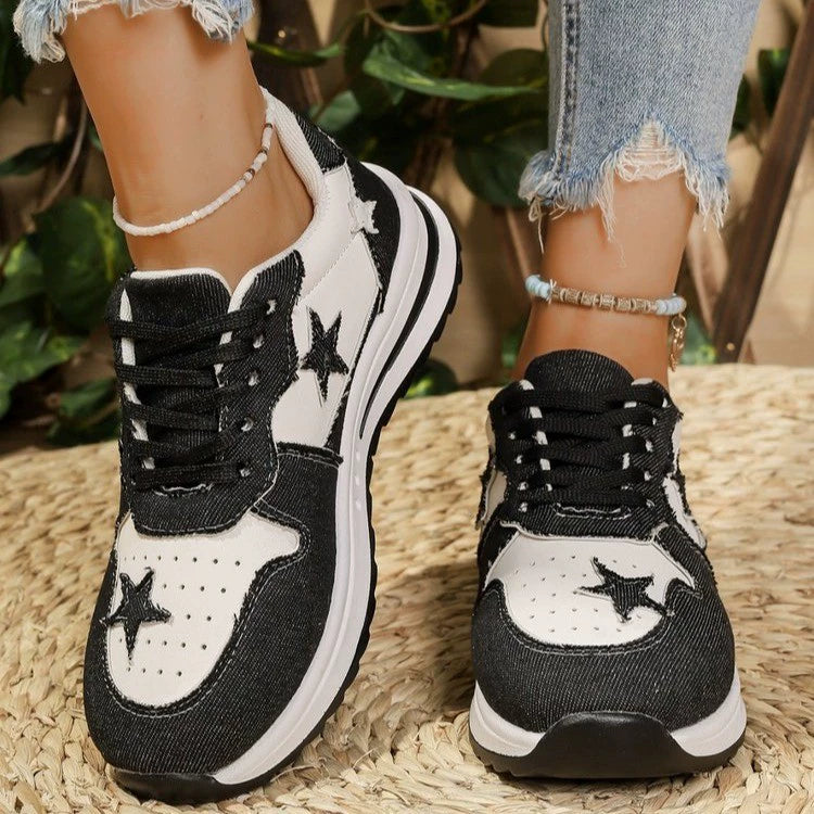 Black and white lace-up sneakers with star details and a chunky sole.