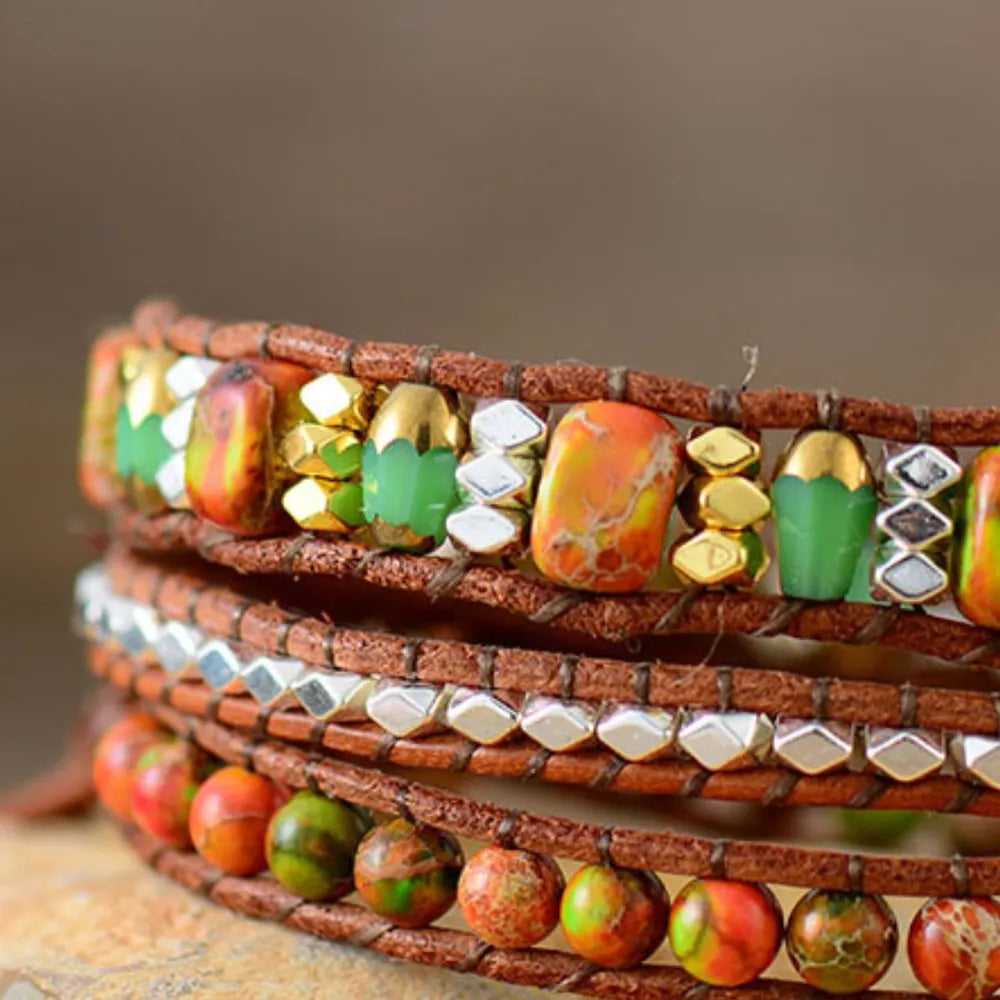 Orange gemstone and leather wrap bracelet with gold and silver beads.