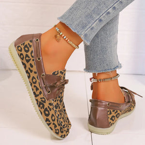 Leopard print boat shoes with leather trim and lace detail.