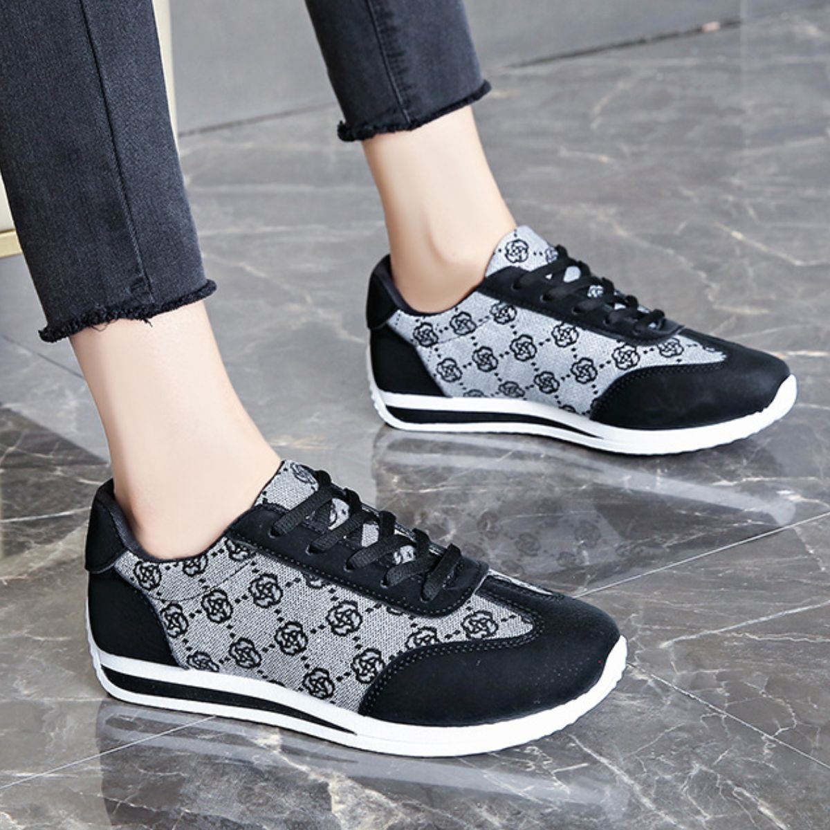 Black and grey patterned lace-up round toe sneakers with white soles.
