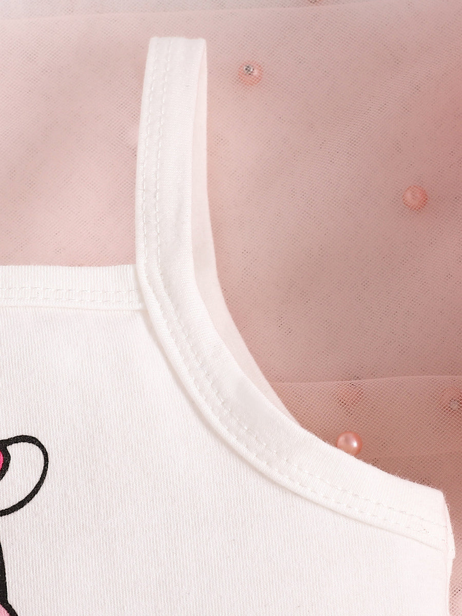 White cotton baby tank top with cow print detail and pink tulle overlay.