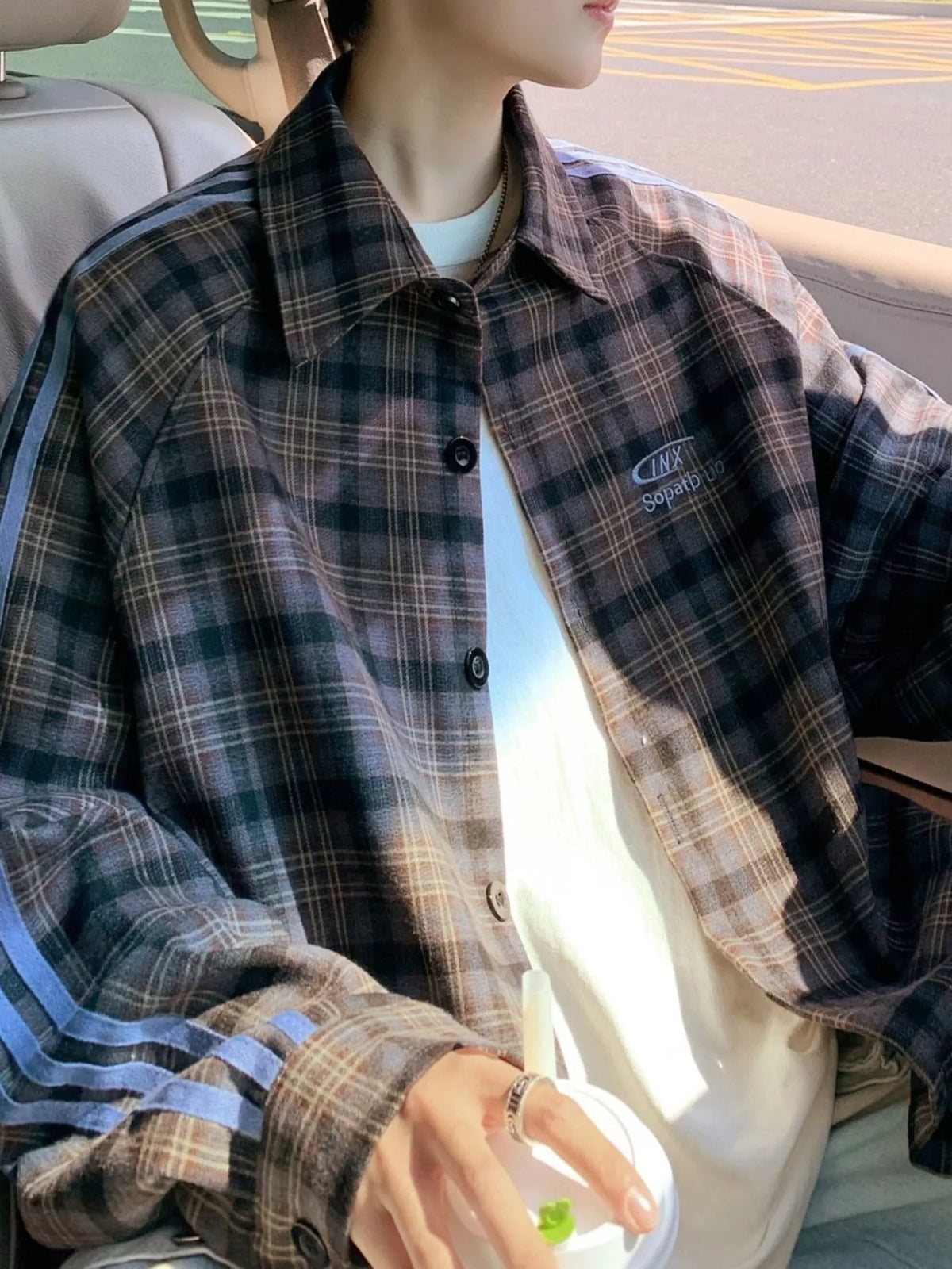 Oversized plaid long-sleeve overshirt in black with blue stripe detail on sleeves.