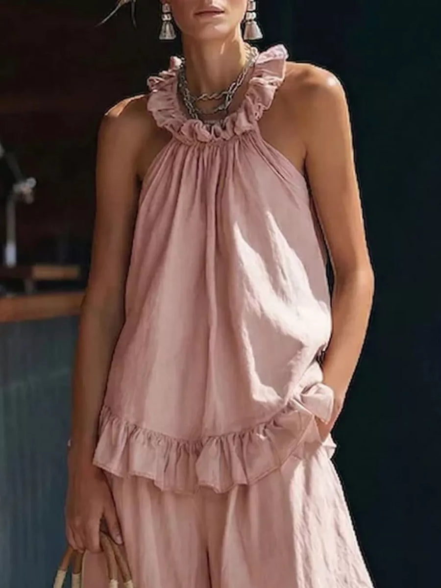 Pink ruffled halter neck top and wide-leg pants set with frill details.