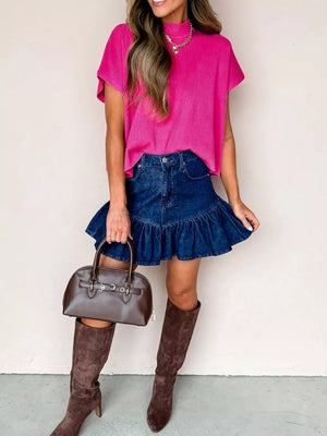 Relaxed mock neck knit top in bright pink with short sleeves and a ribbed texture.
