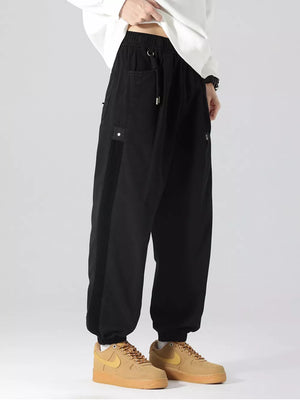 Black oversized cargo joggers with drawstring and side stripe detail.