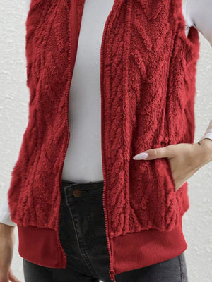 Red faux fur zip-up vest with textured pattern and ribbed hem.