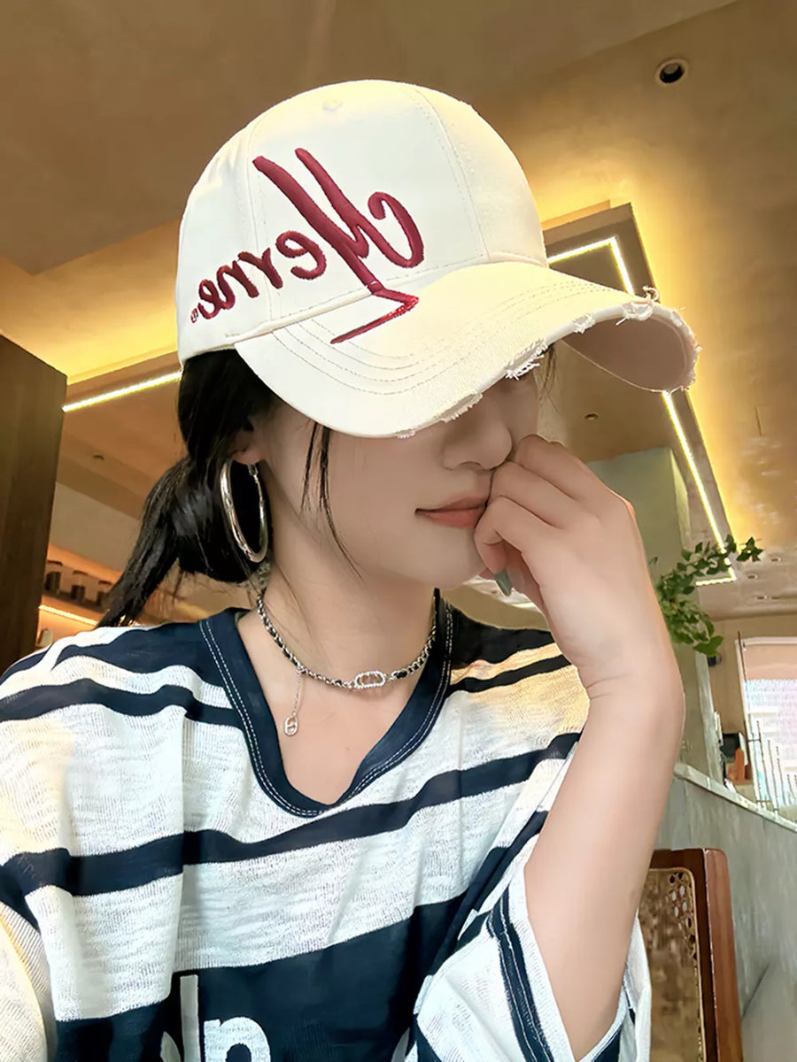 White baseball cap with distressed brim and red embroidered logo