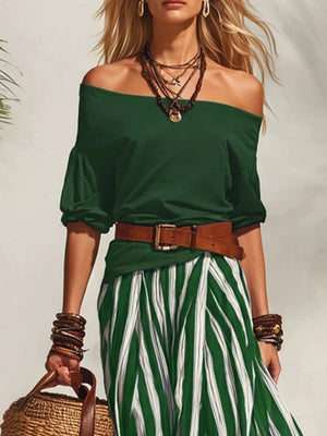 Green off-shoulder top with puffed sleeves and a green and white striped skirt, belted at the waist.