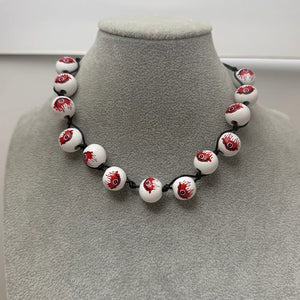 red necklace featuring beaded and eyeball-print