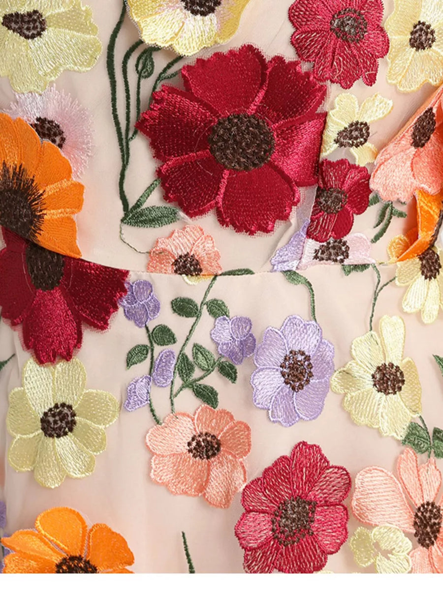 Sheer dress with embroidered floral appliques in red, orange, yellow, pink, and purple.