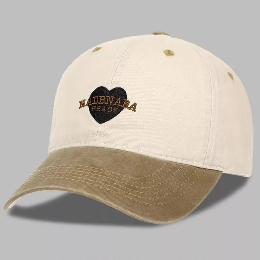 Vintage-washed baseball cap in cream and tan with embroidered heart and text detail.