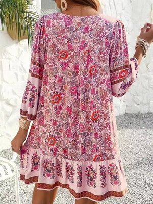 Vibrant floral print mini dress in blush pink with tiered ruffle hem and bell sleeves.