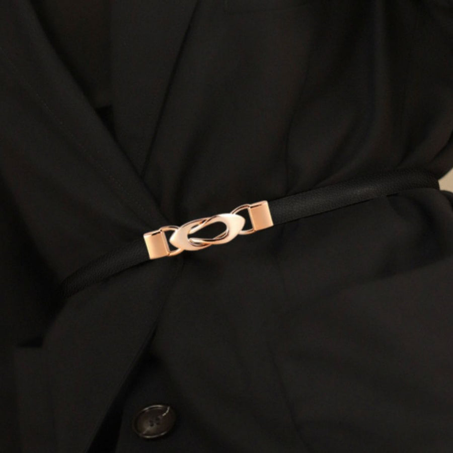 Black leather belt with interlocking gold buckle detail on a black blazer.