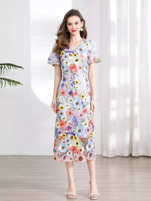 Midi dress with V-neck, short puff sleeves, and all-over floral embroidery in pastel colors.