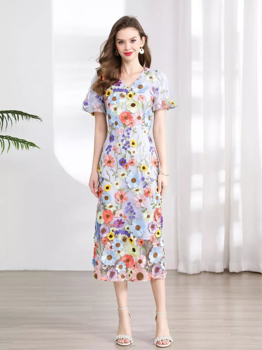 Midi dress with V-neck, short puff sleeves, and all-over floral embroidery in pastel colors.