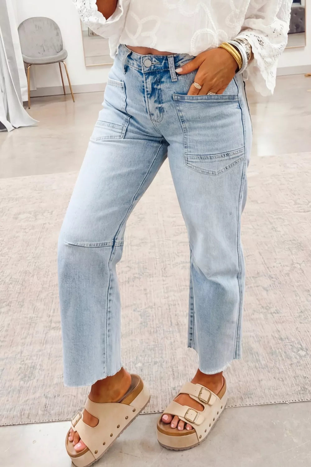 Light wash denim jeans with raw hem and utility pockets