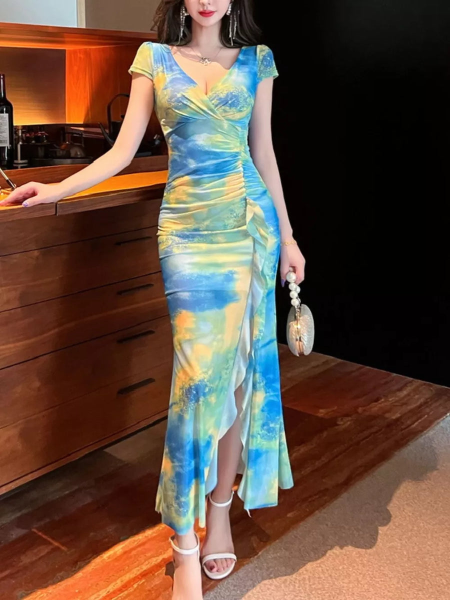 Surplice ruffle maxi dress in blue and yellow tie-dye with ruched side and high slit.