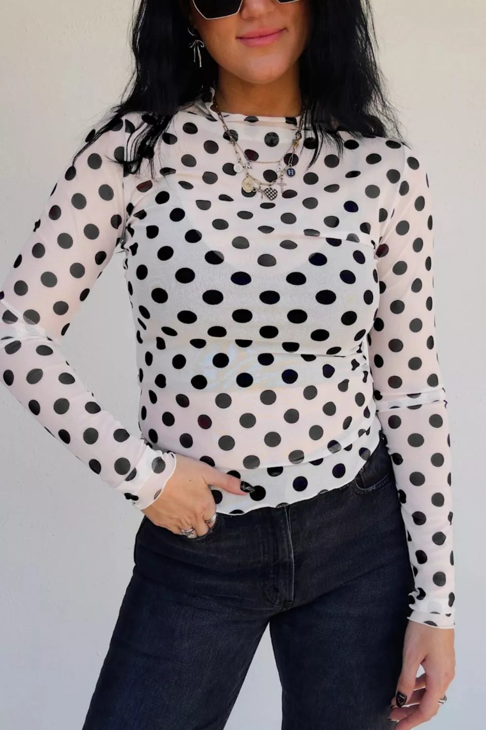 White polka dot mesh mock neck shirt with lettuce trim sleeves and hem