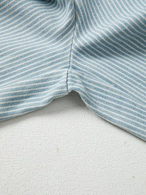 Light blue striped drawstring jeans detail showing seam and fabric texture.