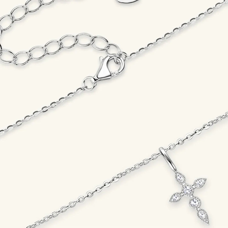 Silver pendant necklace with diamond-set cross and adjustable chain.