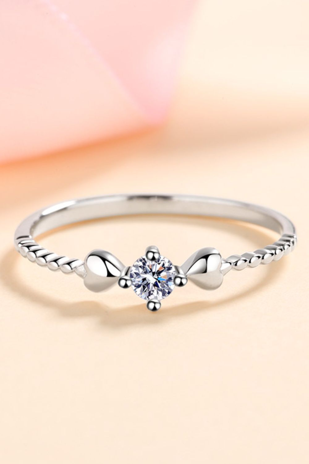 Silver ring with moissanite center stone and heart details