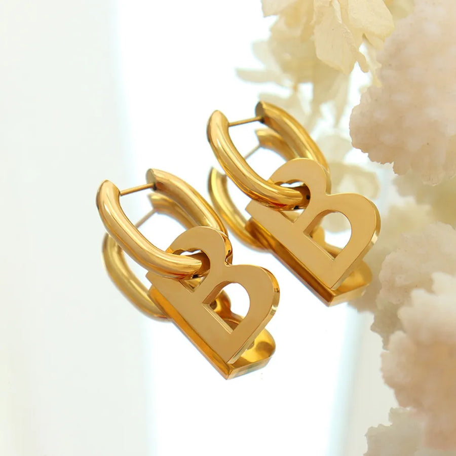 Gold titanium statement hoop earrings with bold letter charms