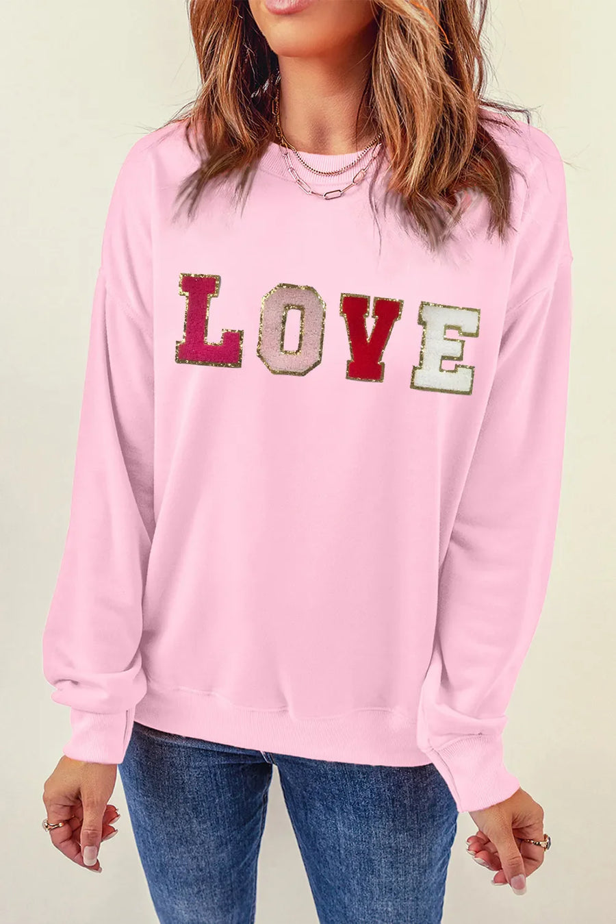 Blush pink sweatshirt with sequin and embroidered LOVE graphic.