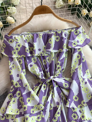 Purple floral off-shoulder ruffled romper with tie waist and bell sleeves.