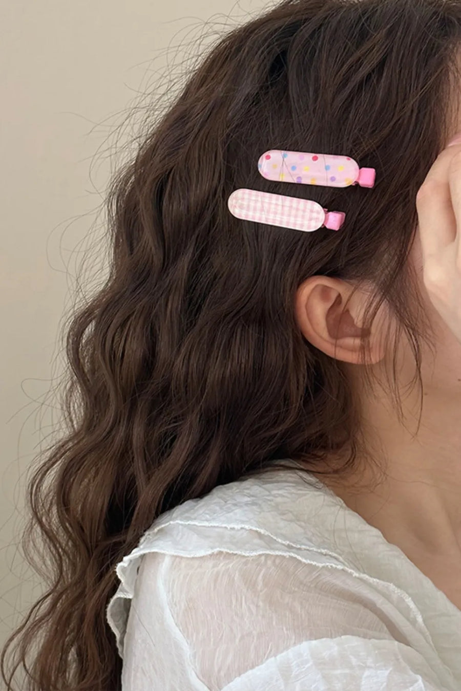 Pastel pink hair clips with polka dot and gingham patterns.