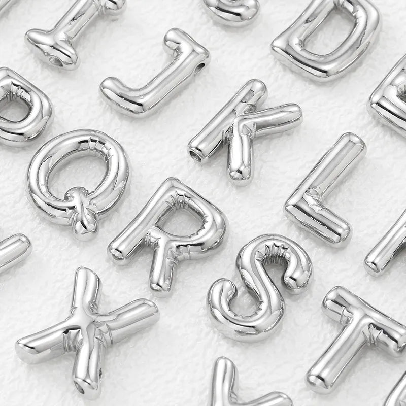 Silver initial pendant charms in various letters, including Q, R, S, T, J, K, L, D, X, and A.