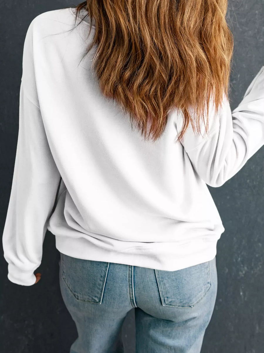White drop shoulder sweatshirt with long sleeves, styled with jeans.